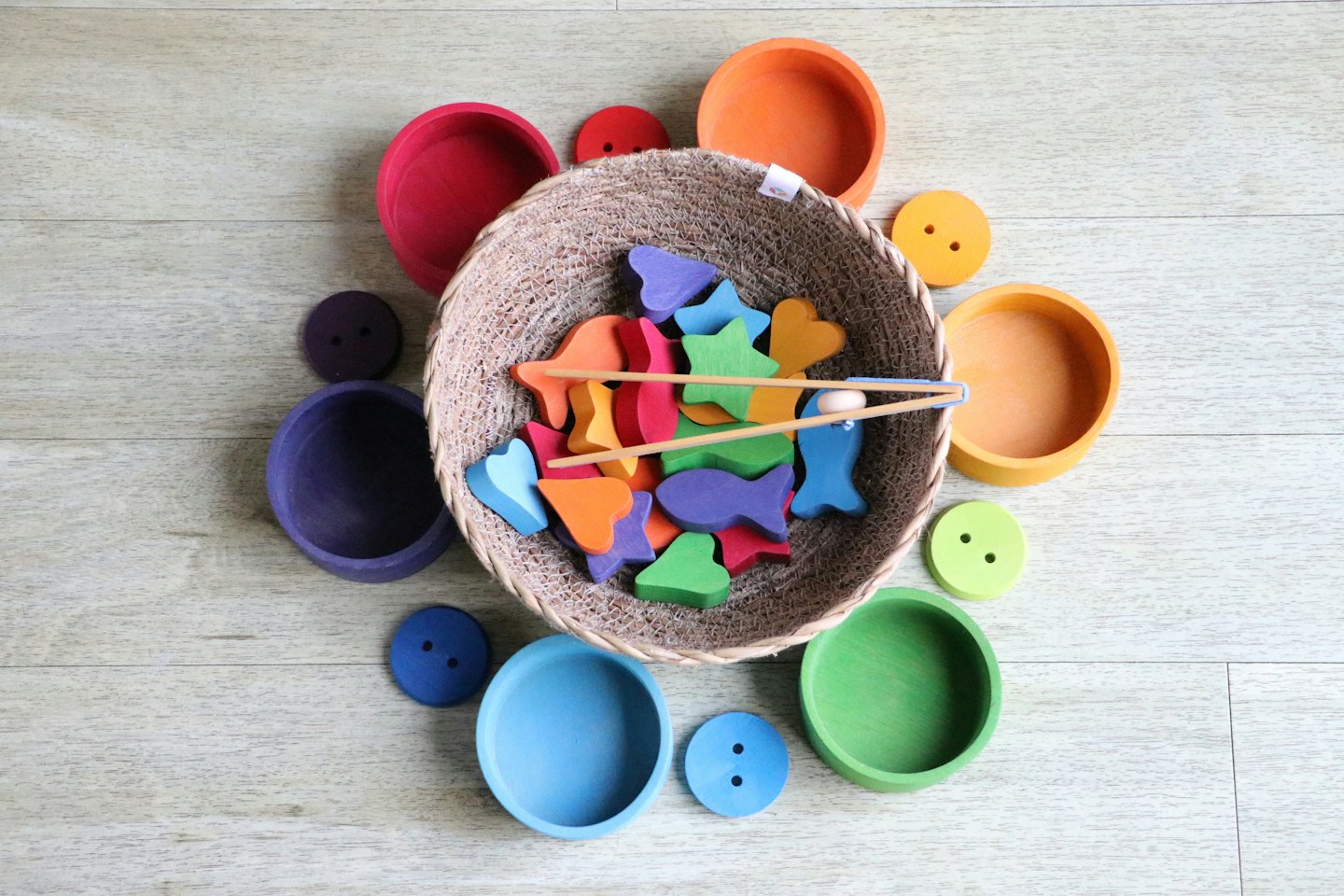 Bunte Holzspielzeuge, die aus einem geflochtenen Korb quellen.