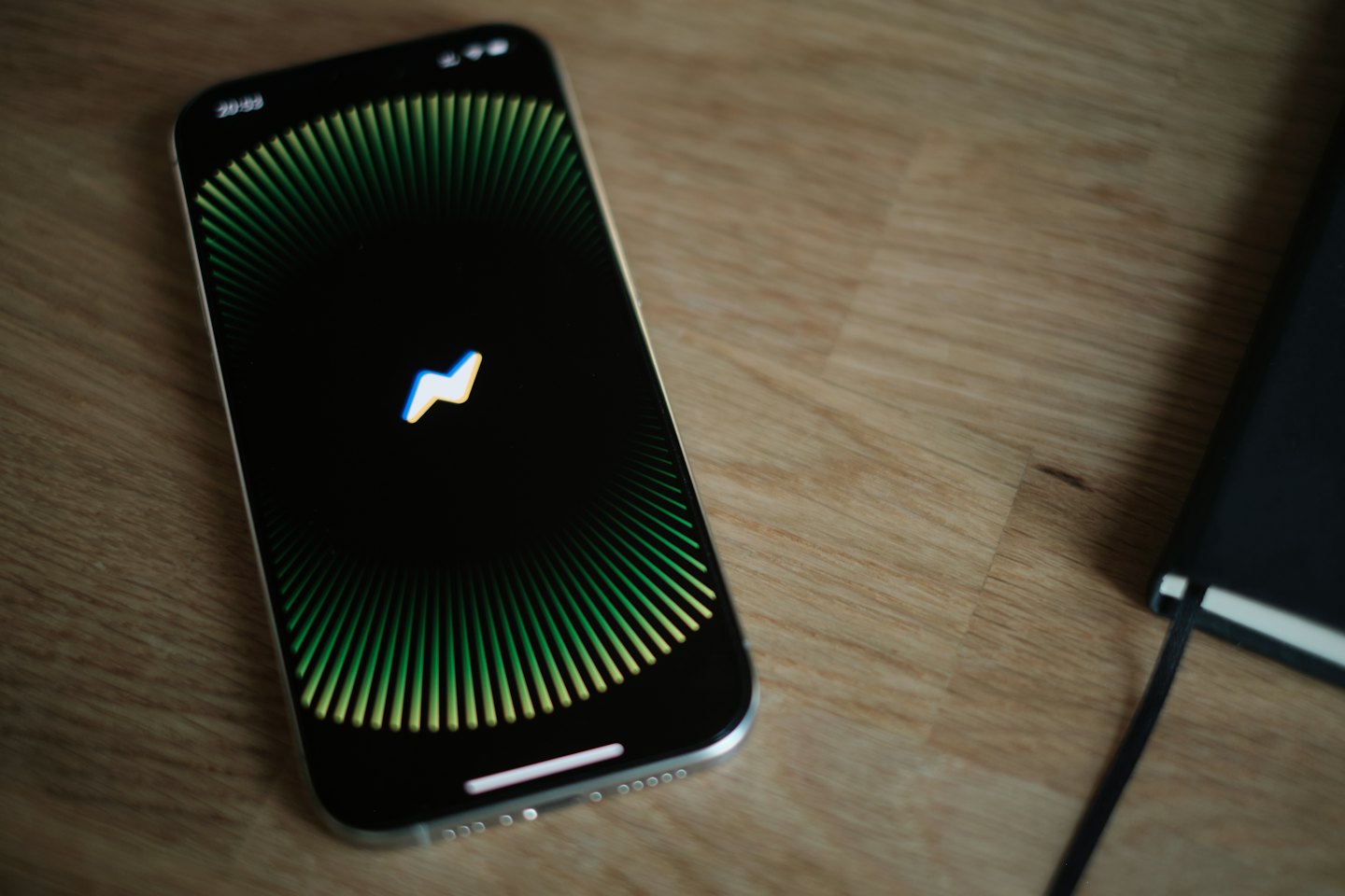 Smartphone mit einem Nachrichten-App-Symbol auf einem Holztisch.
